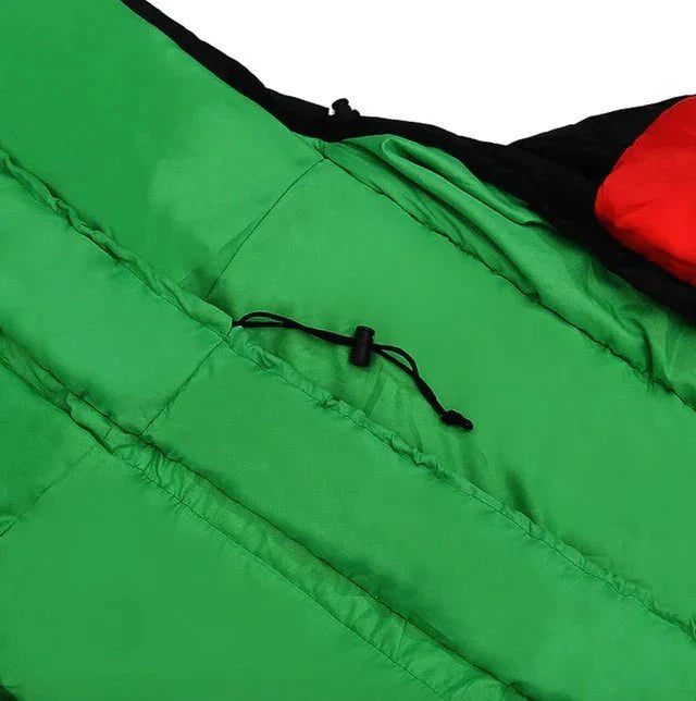 Osoba śpiąca w śpiworze zimowym podczas nocnego biwaku w górach zimą